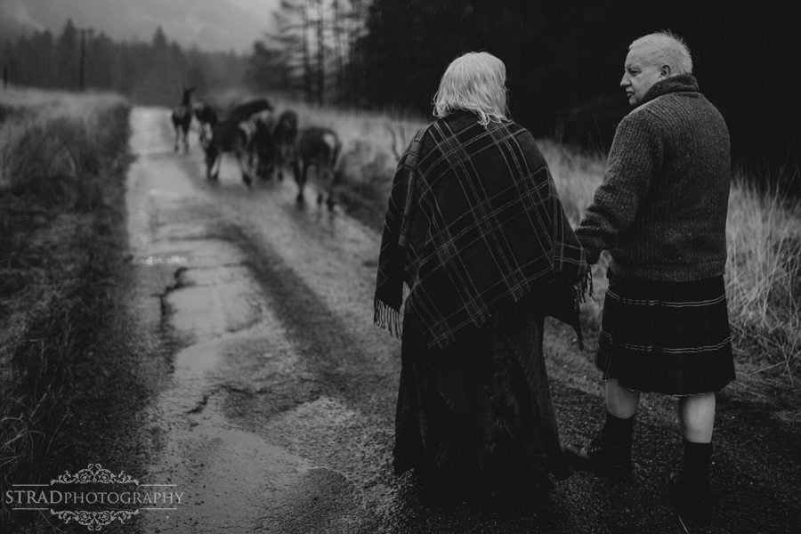 beautiful scenery, deers, elderly couple, engagement photography, glasgow photographer, glen etive, Glencoe, grandma, grandpa, hiking, kilt, landscapes, man and woman, marr, marriage, old couple, old married couple, older couple photo shoot in Glencoe Scotland, outlander, poncho, posing ideas, scotland, scottish couple, scottish highlands, senior couple, tartan
