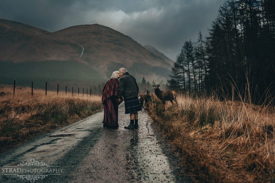 beautiful scenery, deers, elderly couple, engagement photography, glasgow photographer, glen etive, Glencoe, grandma, grandpa, hiking, kilt, landscapes, man and woman, marr, marriage, old couple, old married couple, older couple photo shoot in Glencoe Scotland, outlander, poncho, posing ideas, scotland, scottish couple, scottish highlands, senior couple, tartan