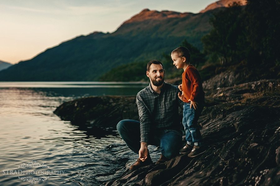 father and son are throwing rocks to the loch lomond