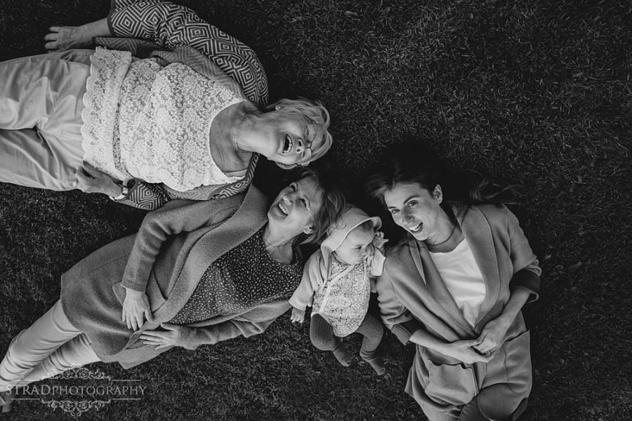 Family of 4 generation of women laying on the grass in front of the visitor centre in Chatelherault Country Park