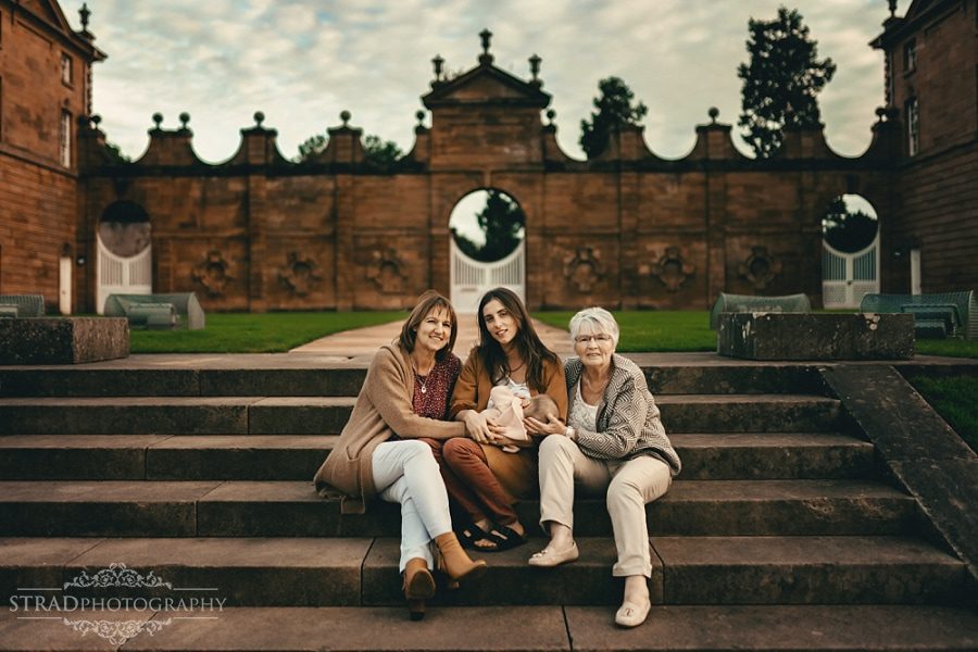 Family of 4 generation of women sitting on the stairs in front of the visitor centre in Chatelherault Country Park