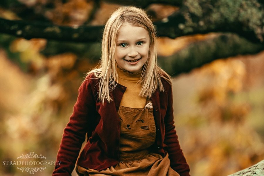 Portrait of a young girl sitting on a tree in Balloch Country Park