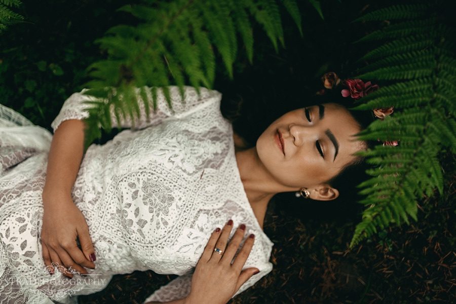 Bride laying on the ground surrounded by leaves