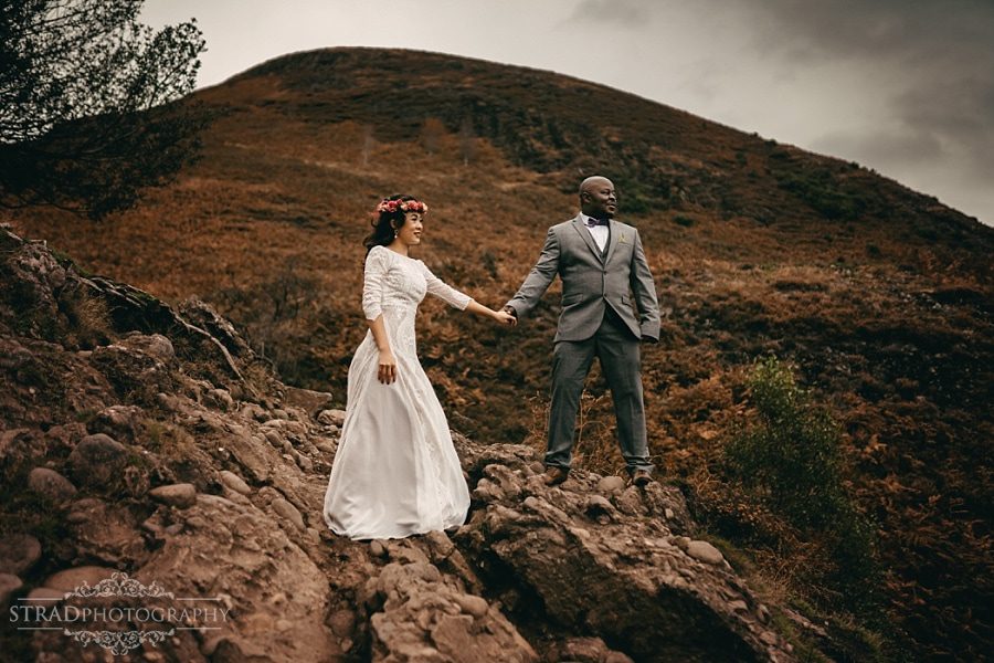 Bride and groom in a super man pose on the way to Conic Hill