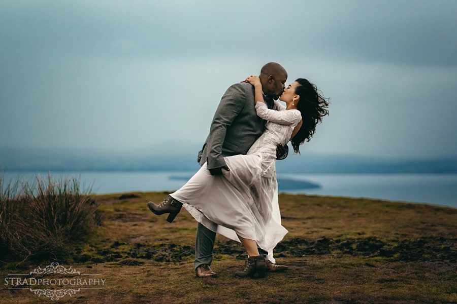 bride and groom kisses on the top of Conic Hill