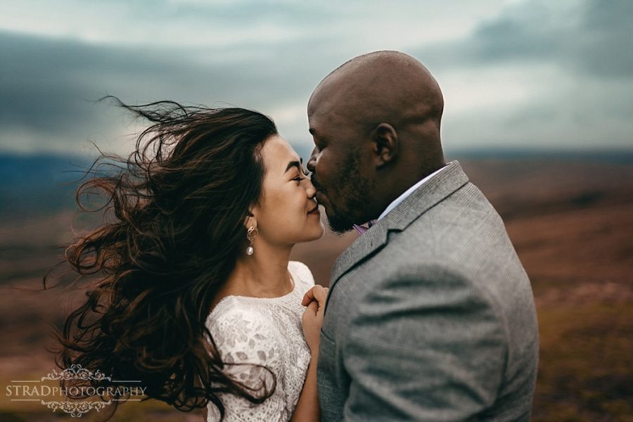 Groom kisses the bride in the nose on the top of Conic Hill