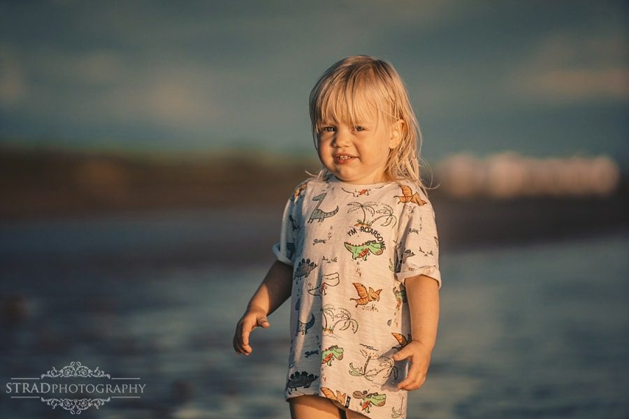 little girl running in the sea during sunset in Ayrshire