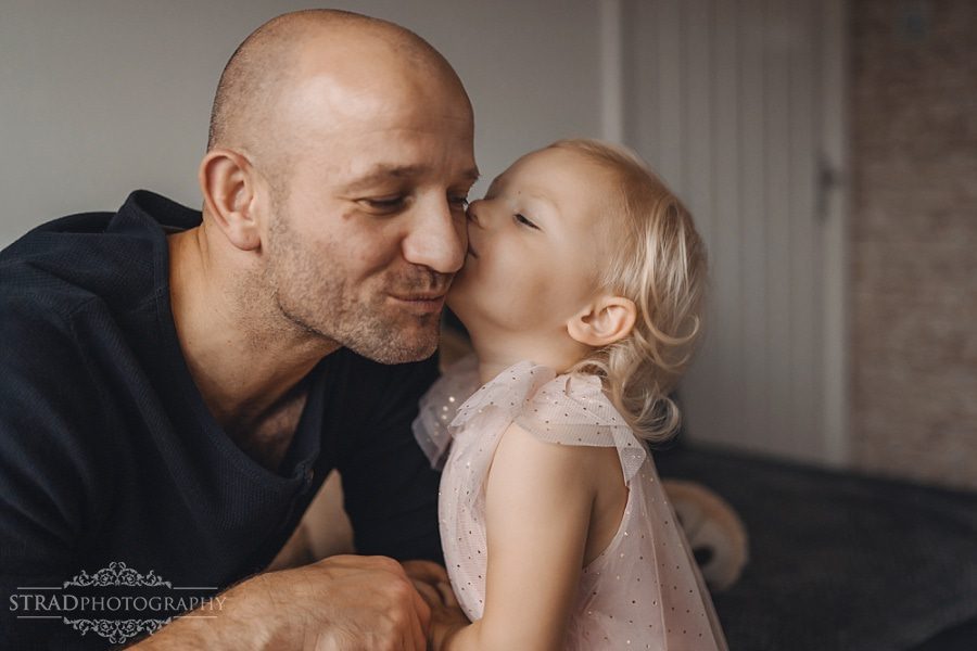 Little girl gives her dad a kiss in the cheek
