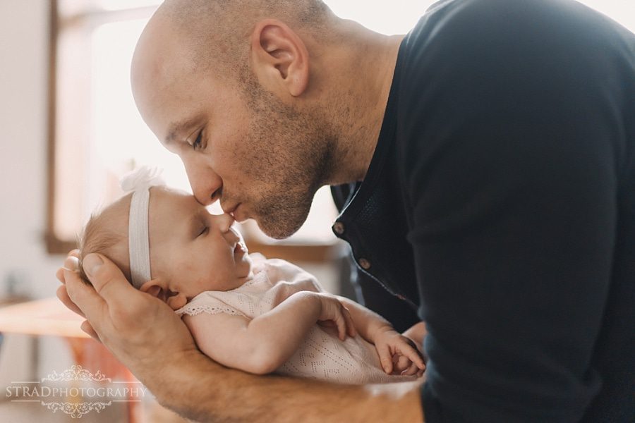 Father holds his newborn daughter in his arms