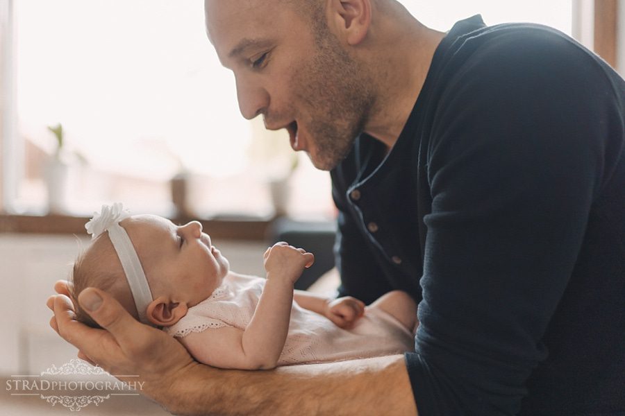 Father holds his newborn daughter in his arms