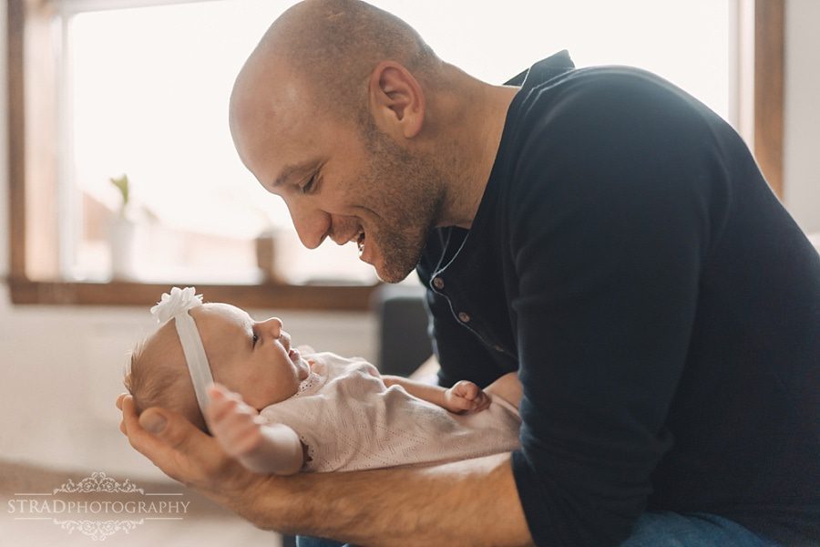 Father holds his newborn daughter in his arms