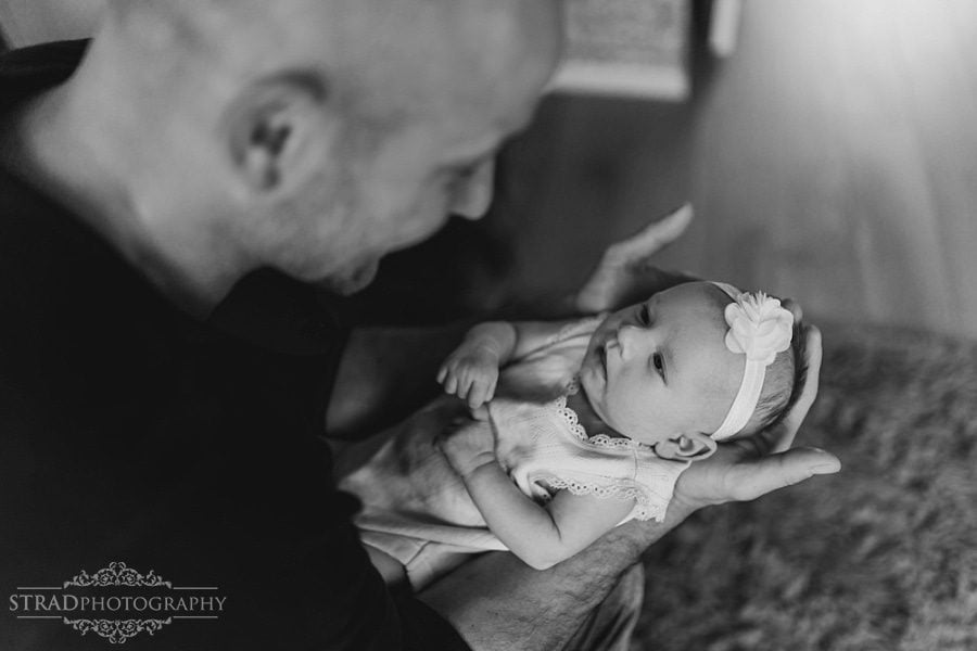 Father holds his newborn daughter in his arms