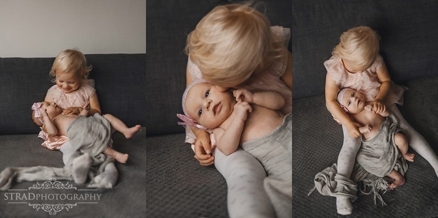 Little girl holding her newborn sister in her arms