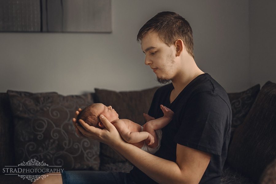 father holds his newborn daughter in his arms