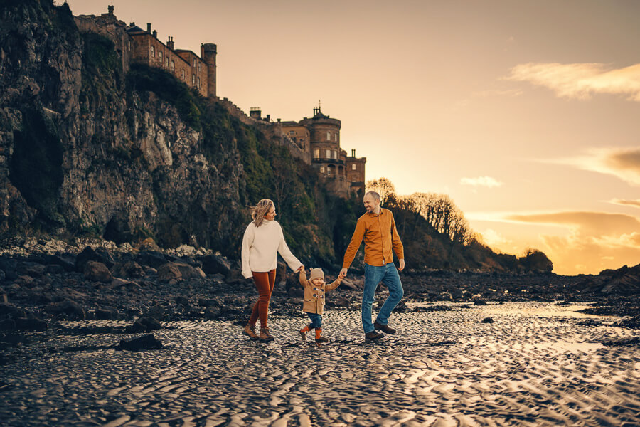 Family walking on a beach at sunset near Culzean Castle.