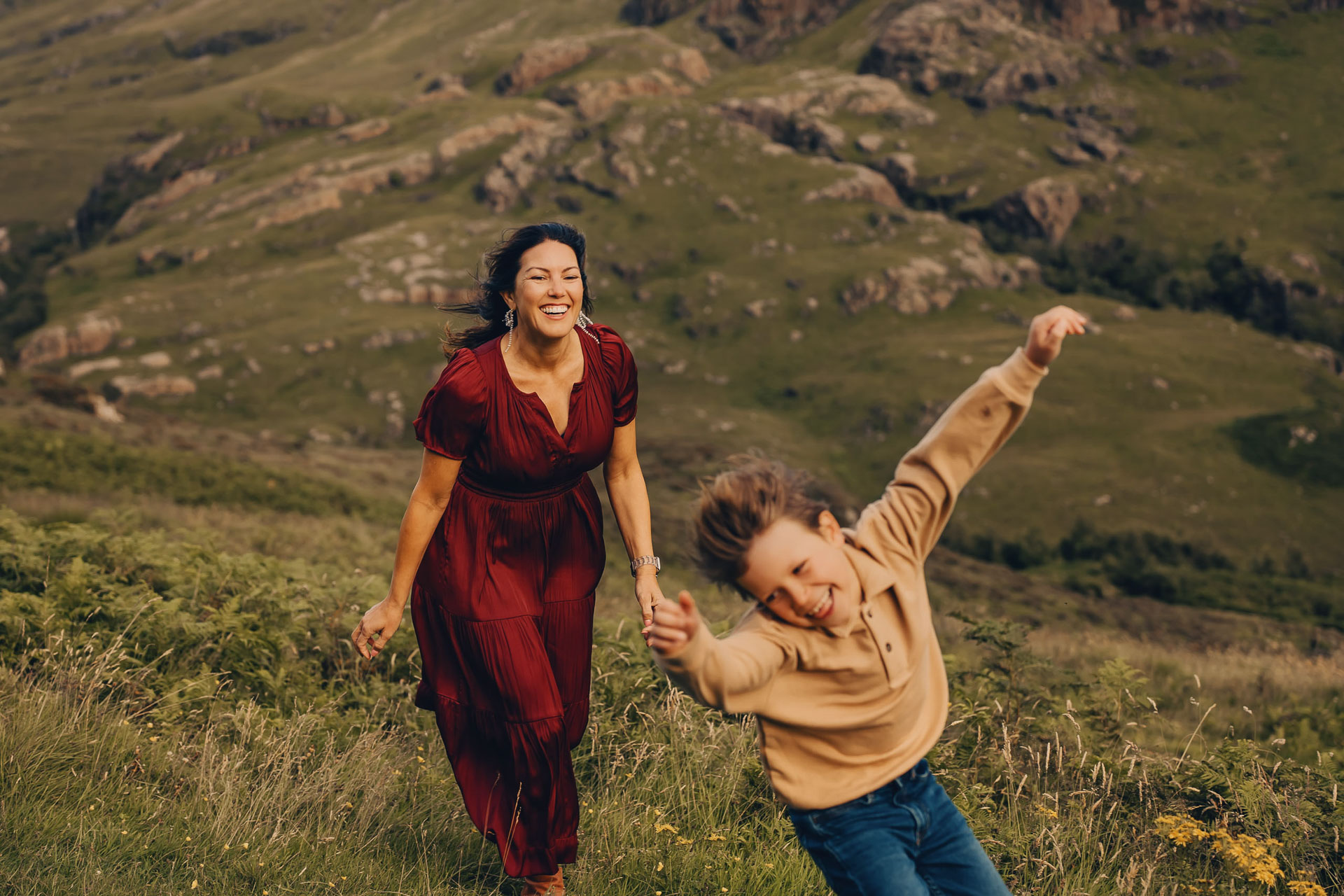 mother playing tag with son in mountains