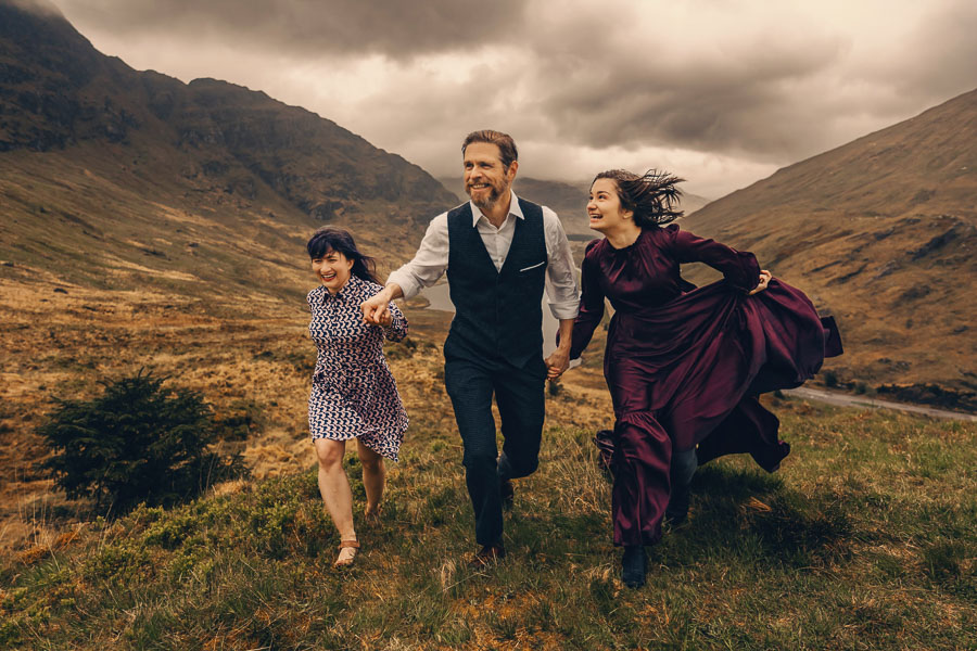 Couple running through dramatic landscape.