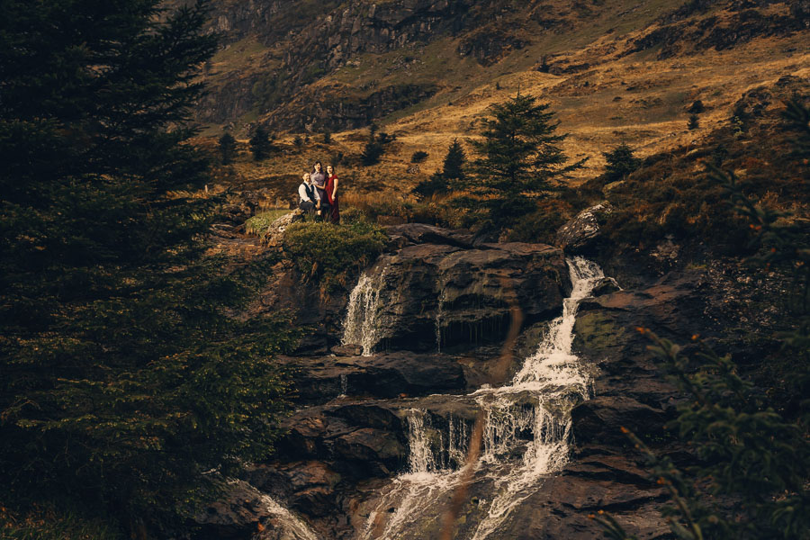 Couple by a scenic waterfall backdrop.