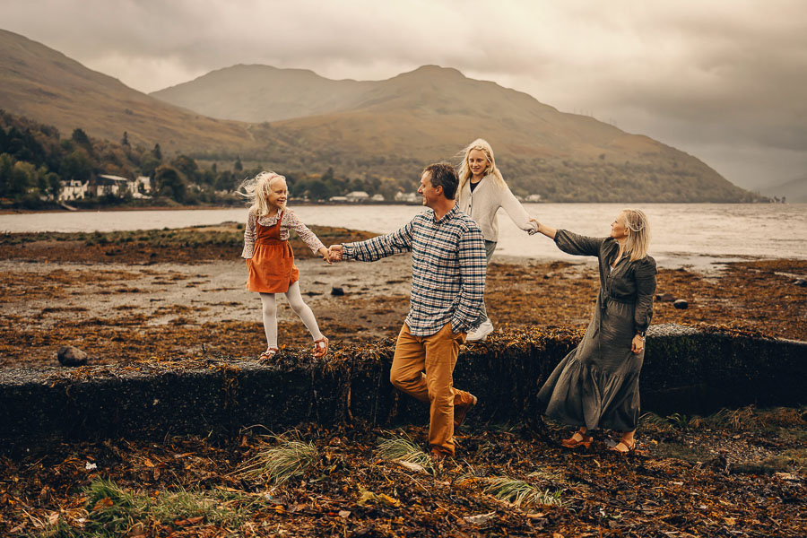 Family walking along a rocky shore.