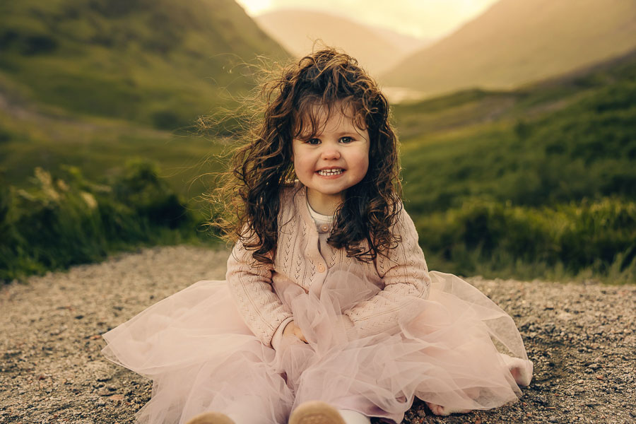 Child in pink dress on path.