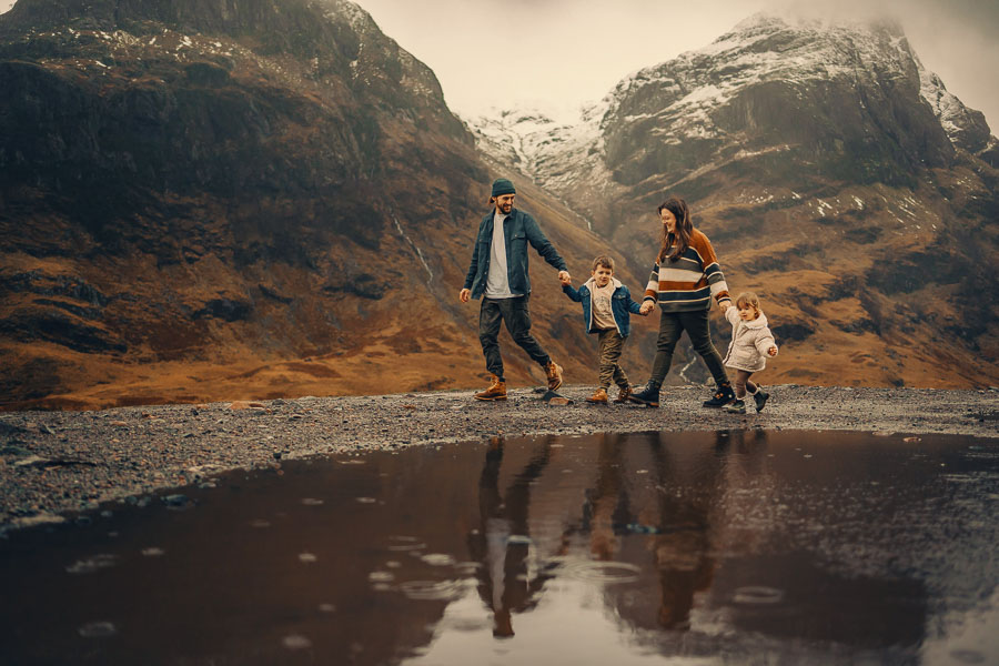 Family walking by a mountain reflection.