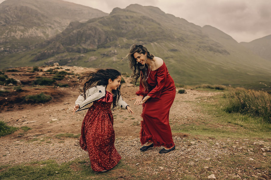 Women in dresses on rocky terrain.
