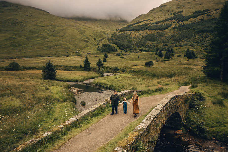 Family on bridge in scenic landscape