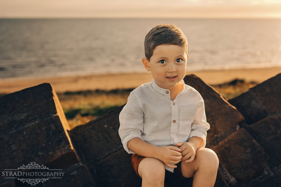 portrait of a 3 year old boy at the beach