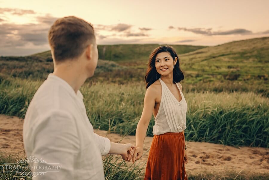 couples holding hands at the beach