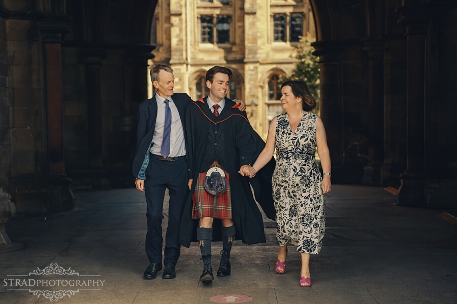 Graduates walking with proud family member.