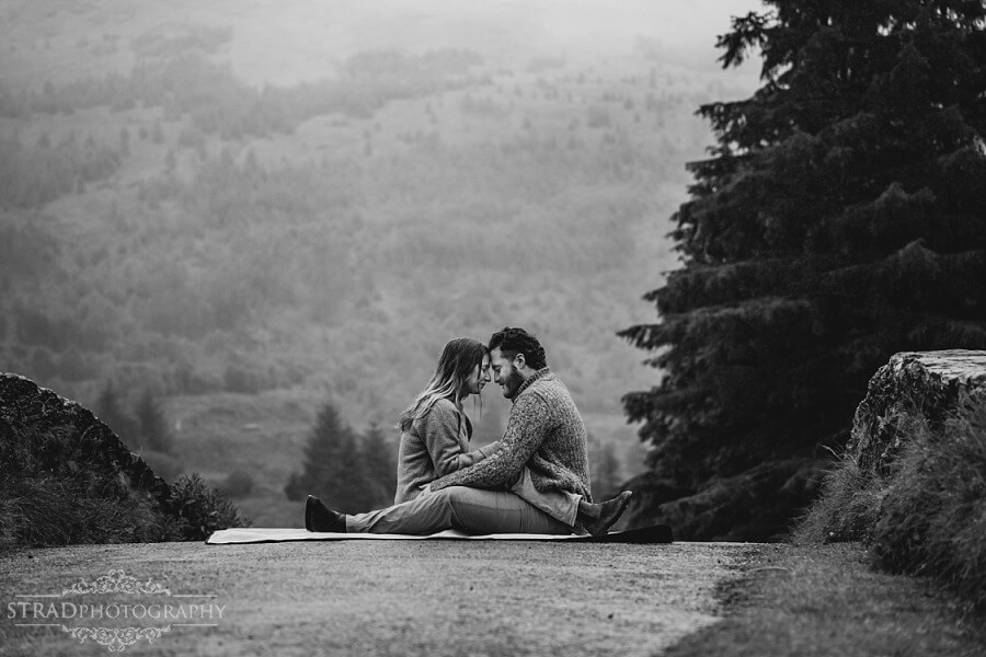 couple sitting in front one another on the bridge