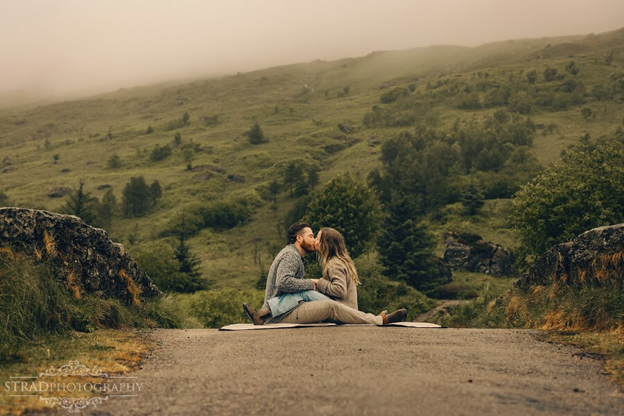 couple sitting in front one another on the bridge