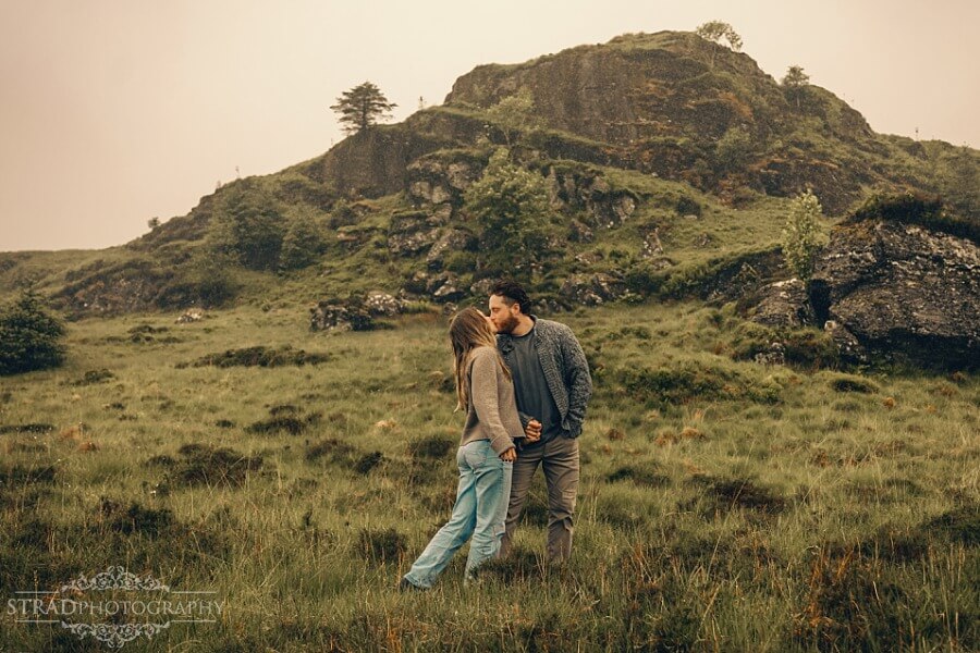 couple kissing with mountain behind them