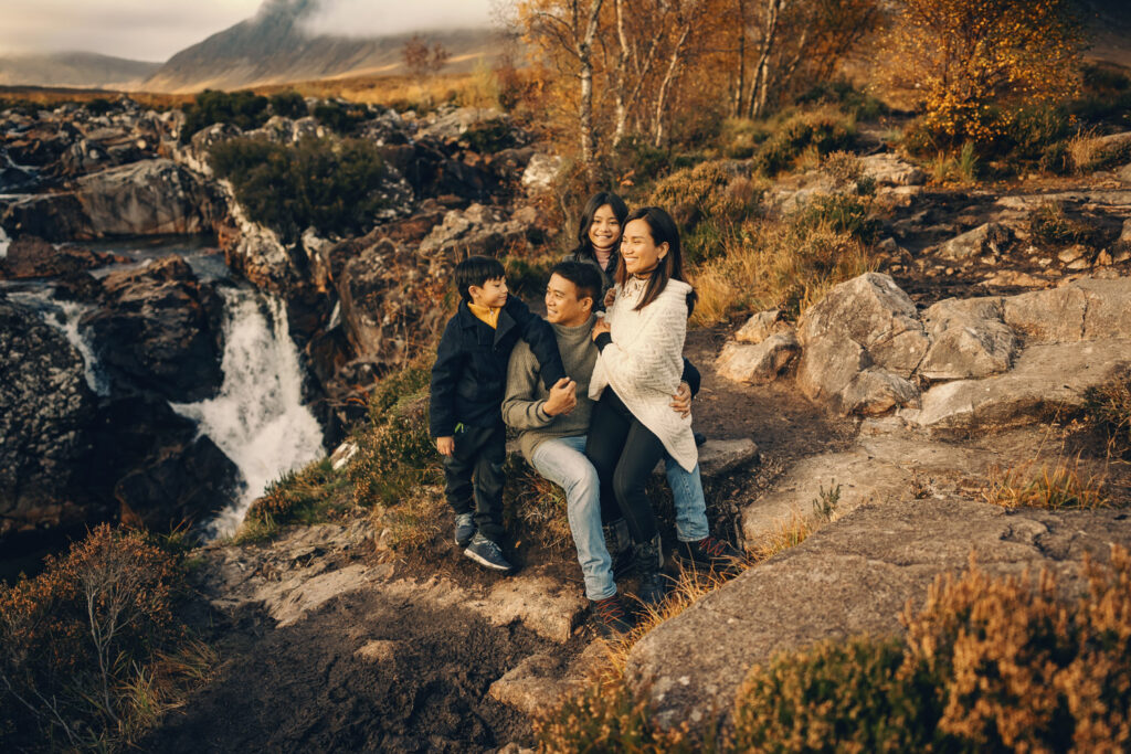 A family from Dubai near waterfall in Glencoe photographed by the Scotland family photographer 