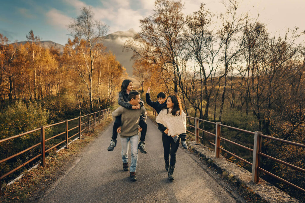 A family is having a piggy back race on the bridge in Glencoe