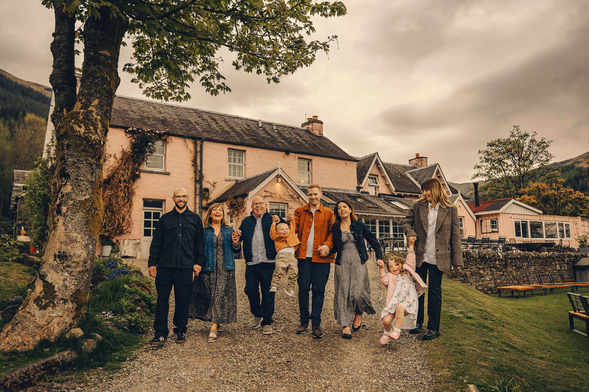 Family walking near a picturesque house.