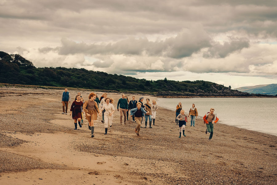 large family running at the beach