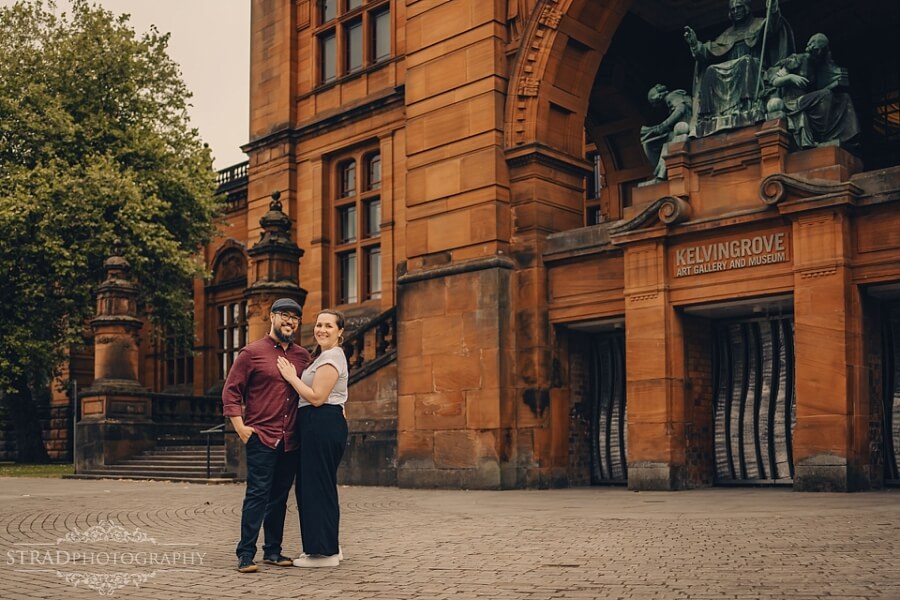 Couple embracing outside Kelvingrove Museum.
