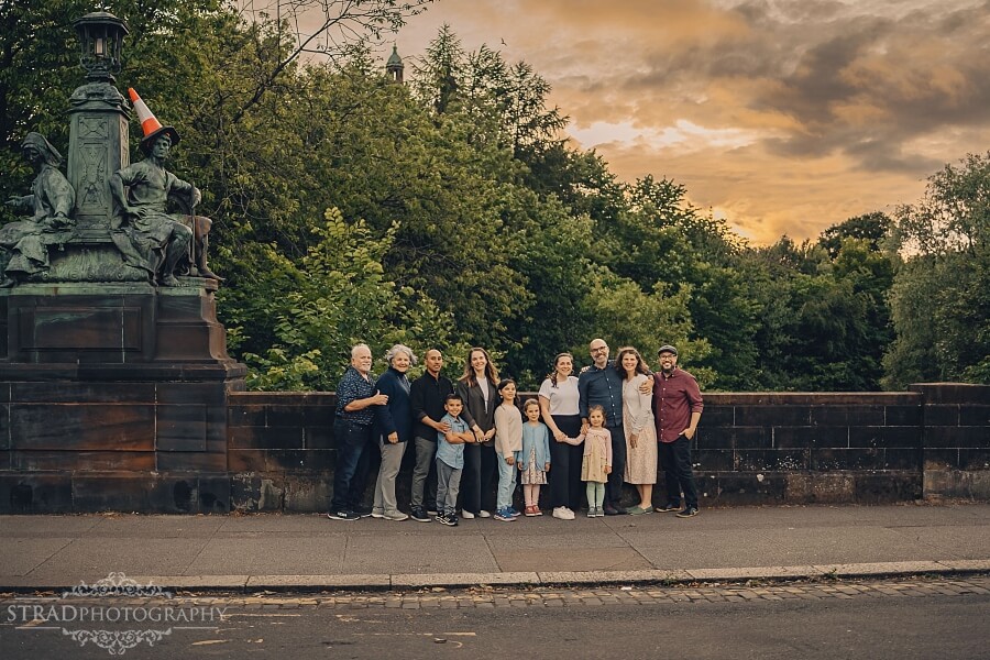 Extended family gathering near a statue. at Kelvin Bridge in Glasgow.
