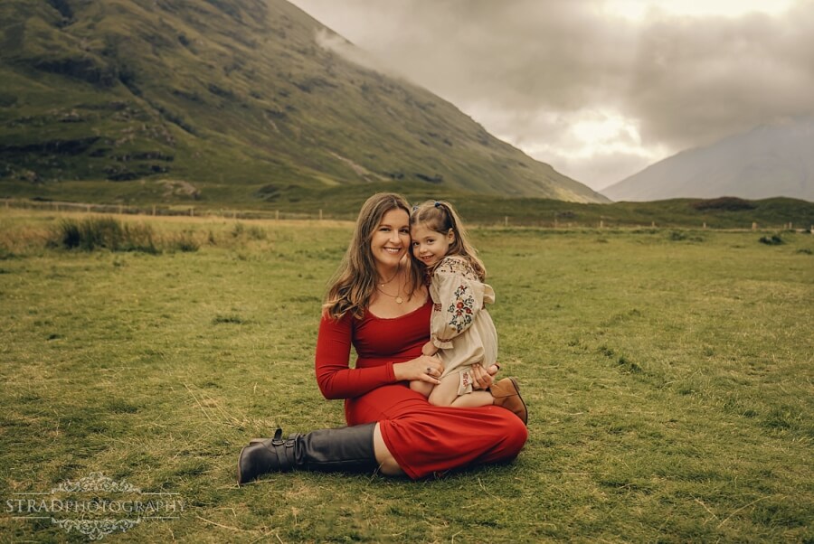 Pregnant mother and child in scenic landscape during maternity photography Glencoe session.