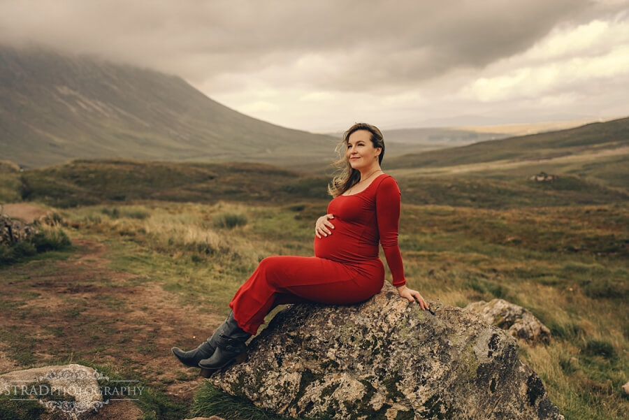 Pregnant woman in red dress outdoors in Glencoe.