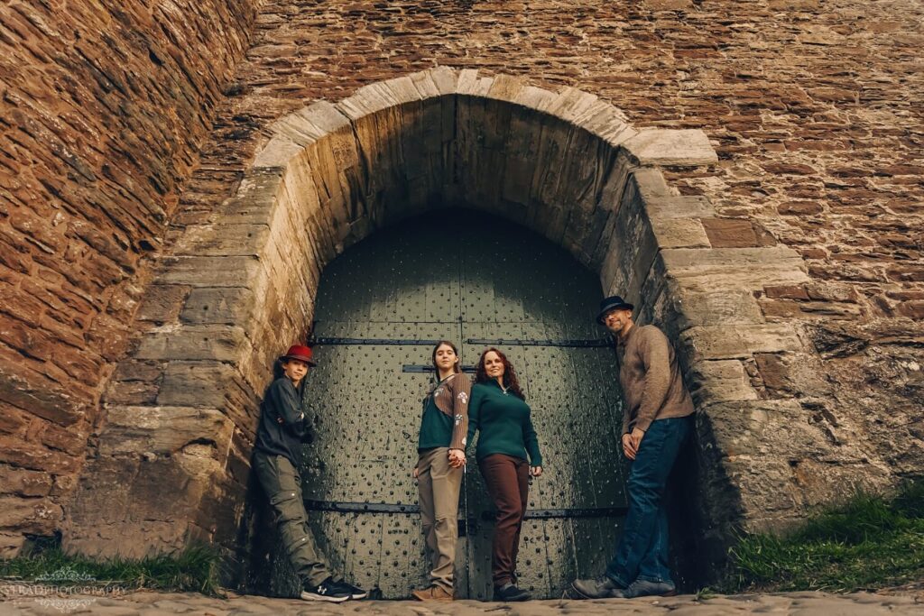 Family posing near a castle door.