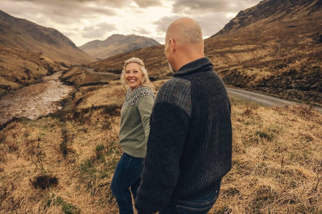 Couple walking in scenic mountain landscape.
