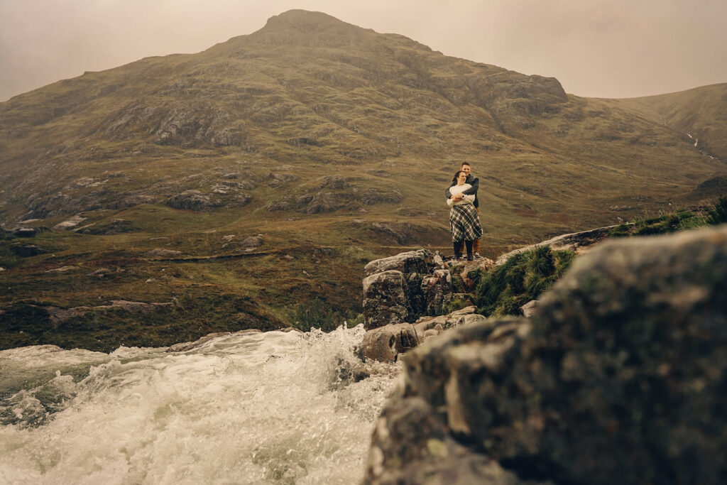 Couple embracing near a waterfall.