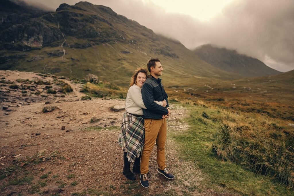 Couple embracing in scenic landscape.