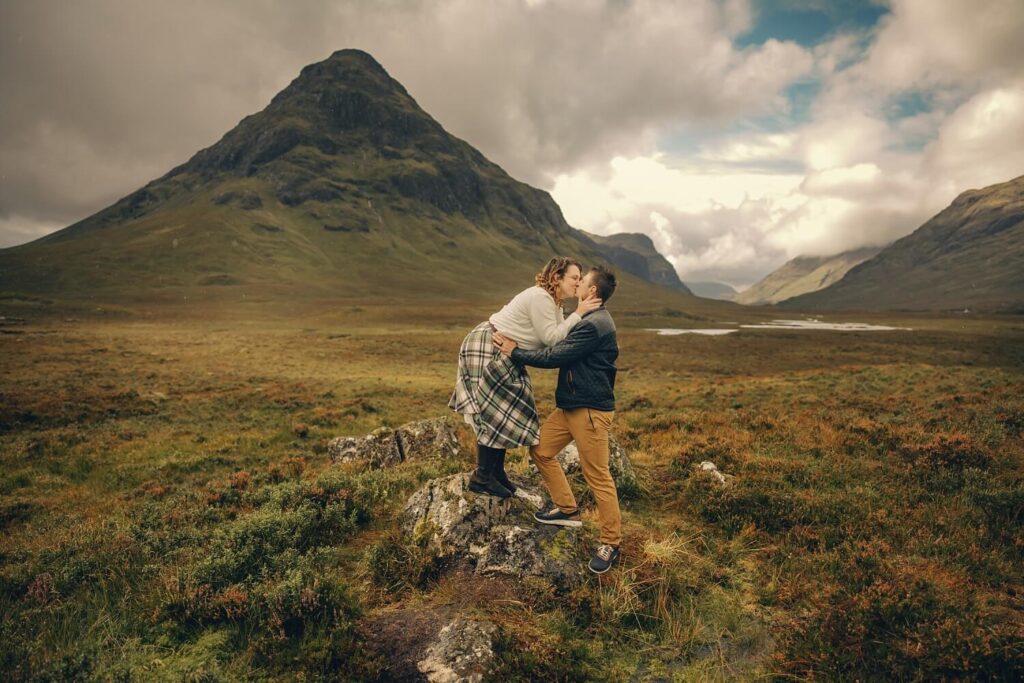 Couple embracing in scenic landscape.