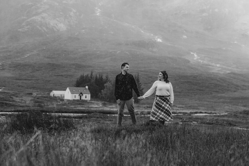 Couple holding hands in landscape.