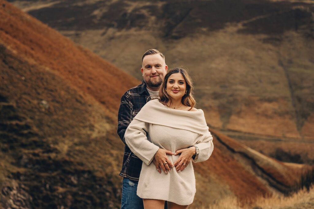 Couple celebrating gender reveal outdoors.