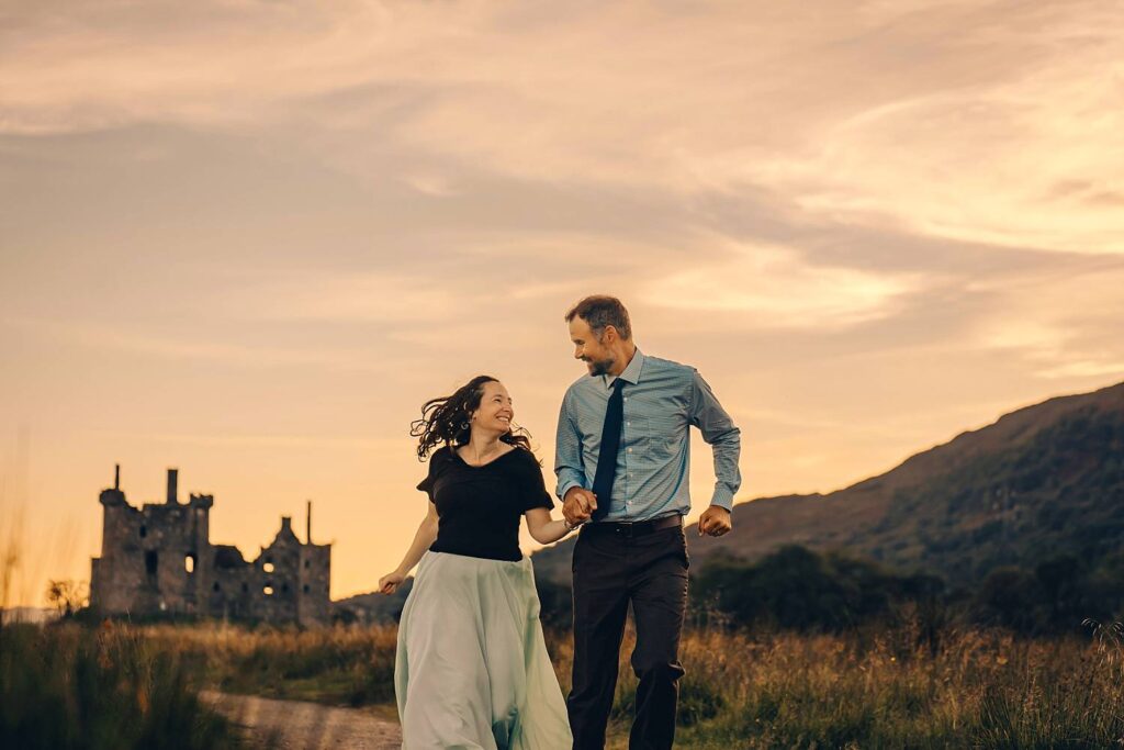 Couple walking hand in hand at sunset.