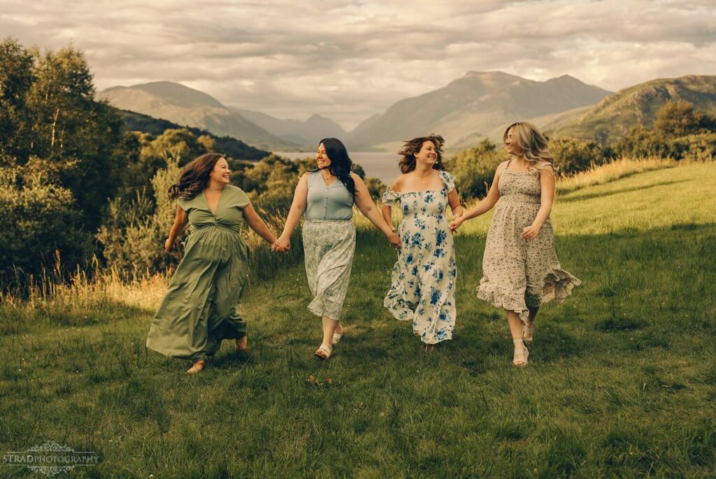 Four women walking hand in hand.